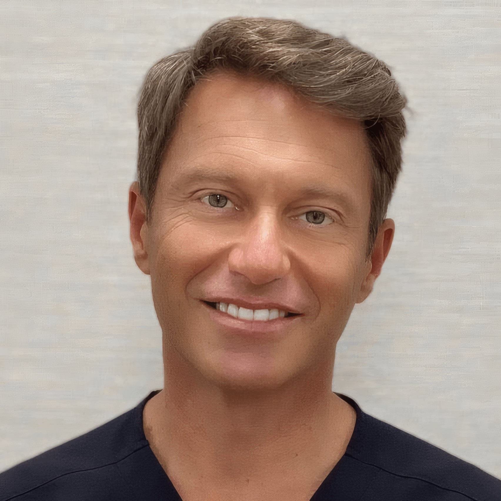 A man with short brown hair wearing a black shirt smiles at the camera against a light, textured background.