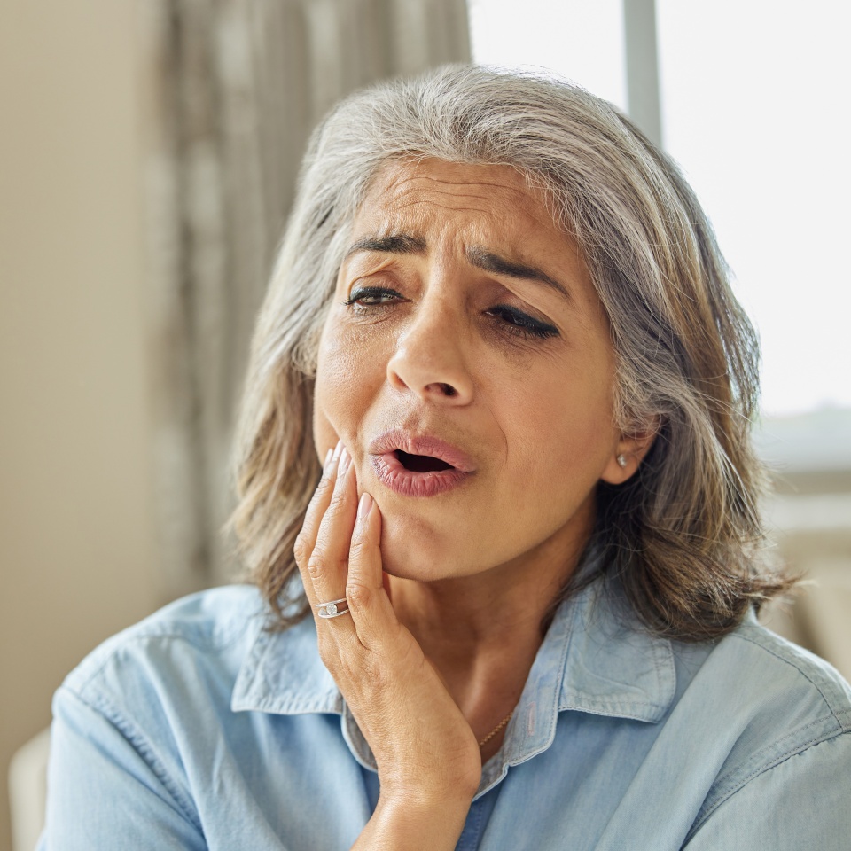 Mature Woman At Home Suffering From Pain With Toothache