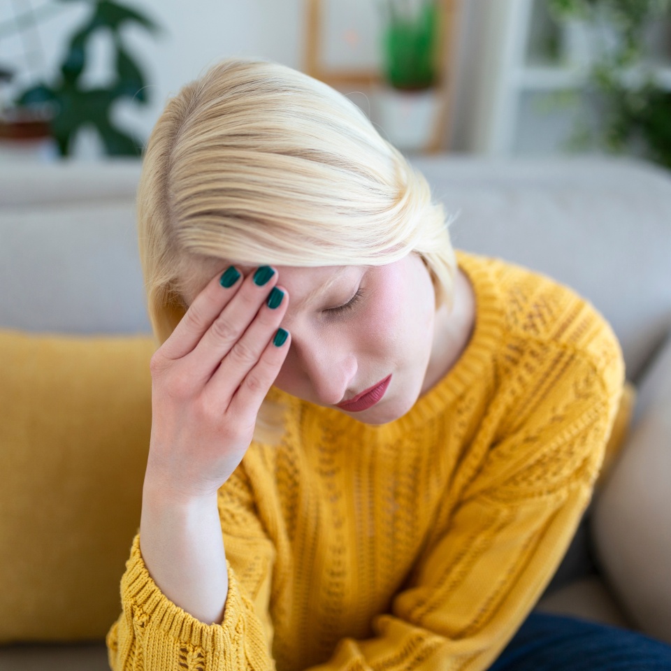 Sinus ache causing very paintful headache. Unhealthy woman in pain. Sharp strong sore. Sinus pain, sinus pressure, sinusitis. Sad woman holding her head because sinus pain