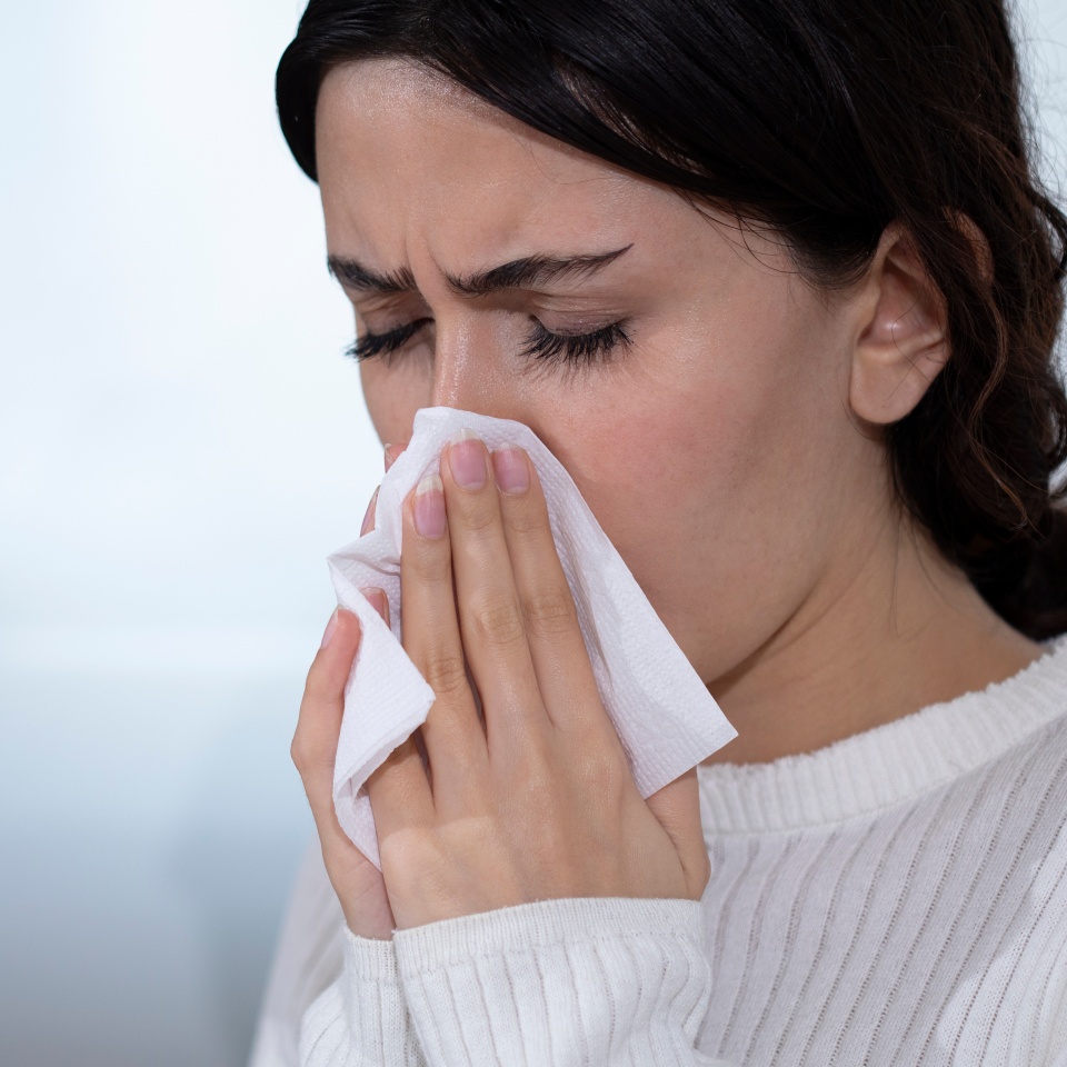 young woman got flue sneezing to paper