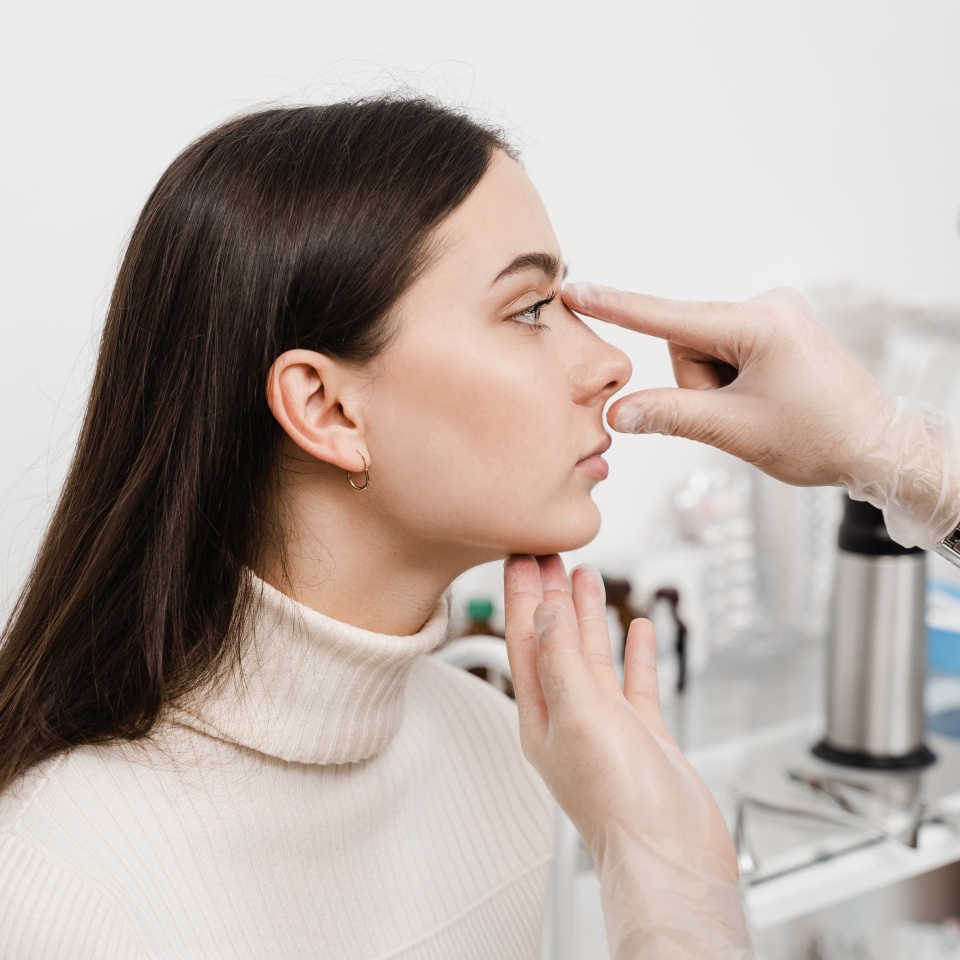 Septoplasty is surgery to correct deviated septum. Rhinoplasty is reshaping nose surgery for change appearance of the nose and improve breathing. Surgeon is touching and examining girl nose