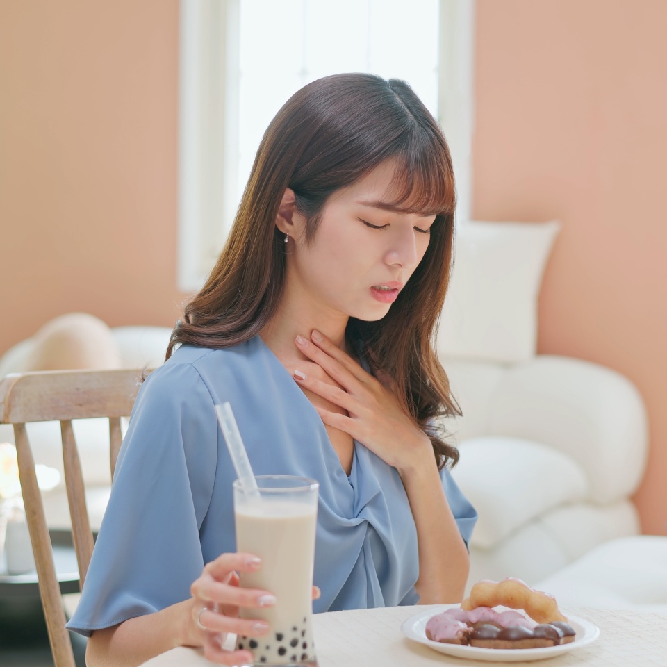 asian woman eat high sugar content food and has Gastroesophageal Reflux Disease feel uncomfortable