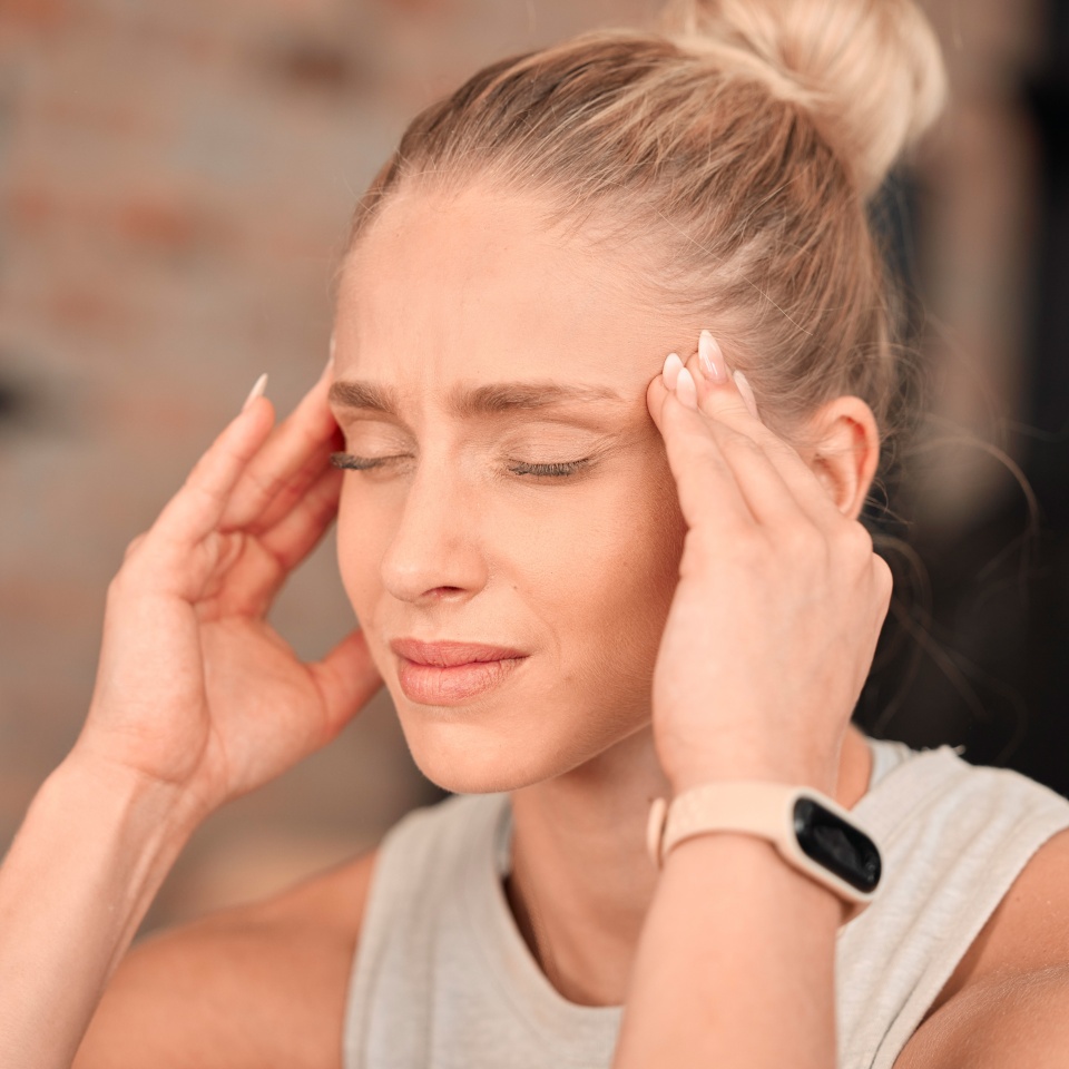 Woman, headache and pain at gym for fitness, exercise anxiety and workout challenge. Face of female athlete with migraine, sports injury and frustrated in struggle of training problem, sick and tired