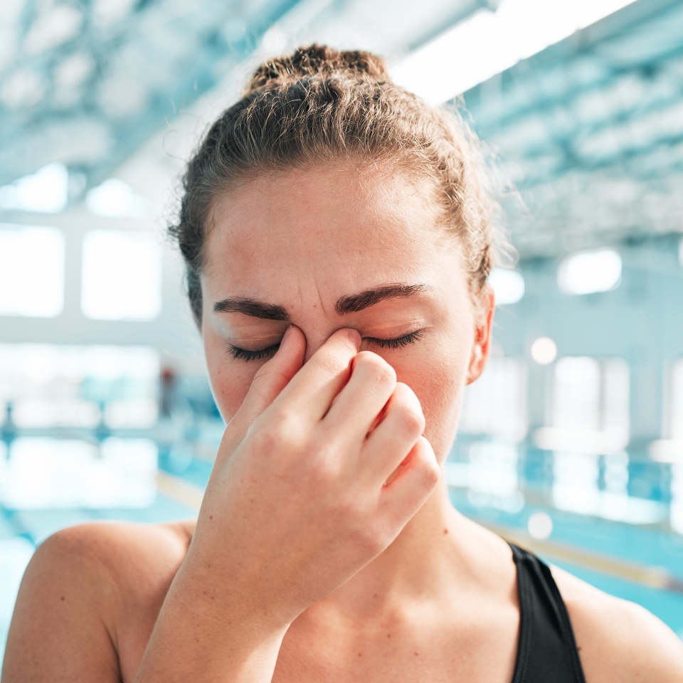 Stress, headache or face of woman swimmer in fitness, exercise or workout with anxiety or fatigue. Tired, hand or sick athlete with migraine, sports injury or head pain frustrated by training problem