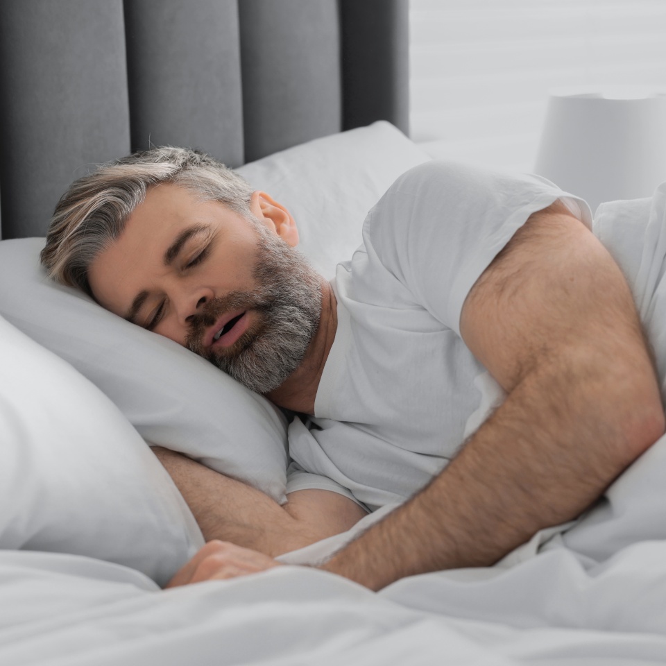 Man snoring while sleeping in bed at home