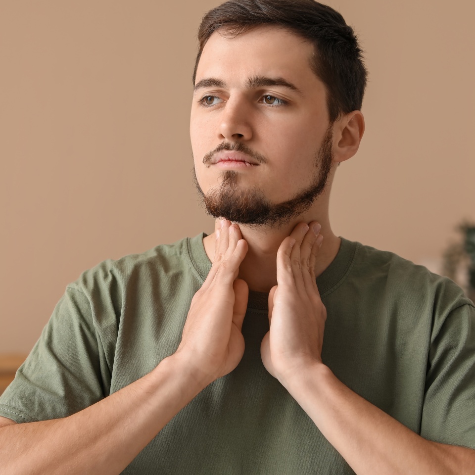 Young man with thyroid gland problem at home
