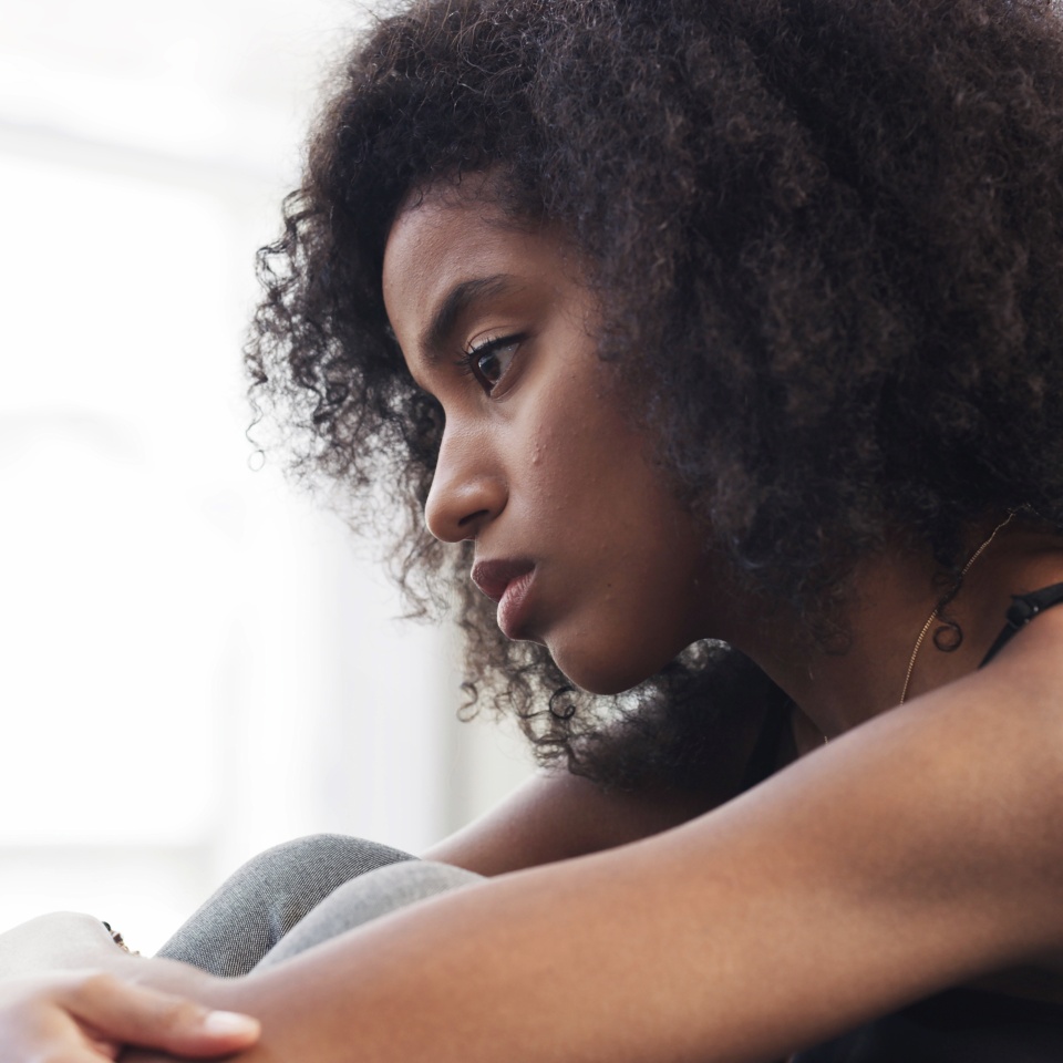 Sad, woman and thinking with depression at house for loneliness, remember past and trauma challenges. African, person and anxiety from stress flashback, mourning loss and ptsd with grief of memory