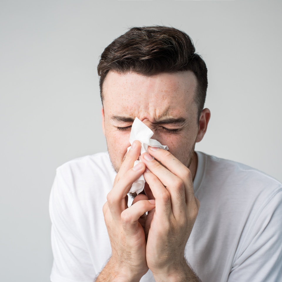 studio picture from a young man with handkerchief. Sick guy isolated has runny nose. man makes a cure for the common cold