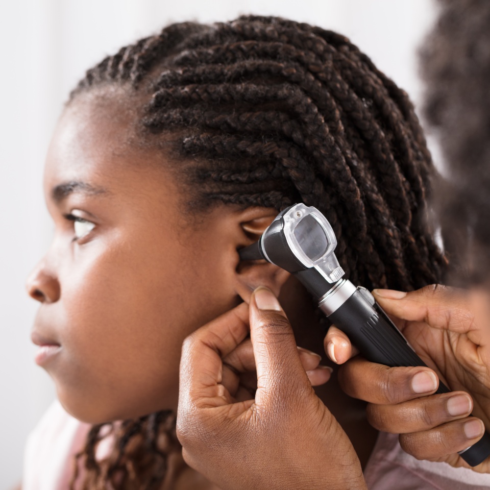 Doctor Using Otoscope Instrument To Check Girl's Ear In Hospital
