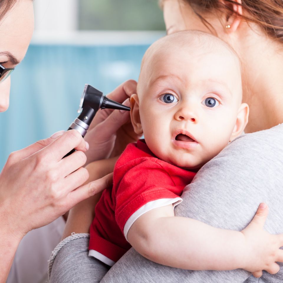 Child's otolaryngologist doing ear examination of infant.
