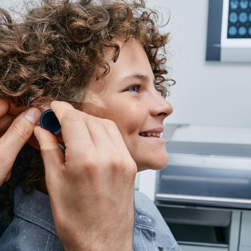 ENT or pediatrician doing professional examination of child patient's ear in doctor office at medical clinic.