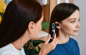 Hearing check-up, otoscopy. Adult woman while ear test with audiologist at medical office. Diagnosis of hear impairment